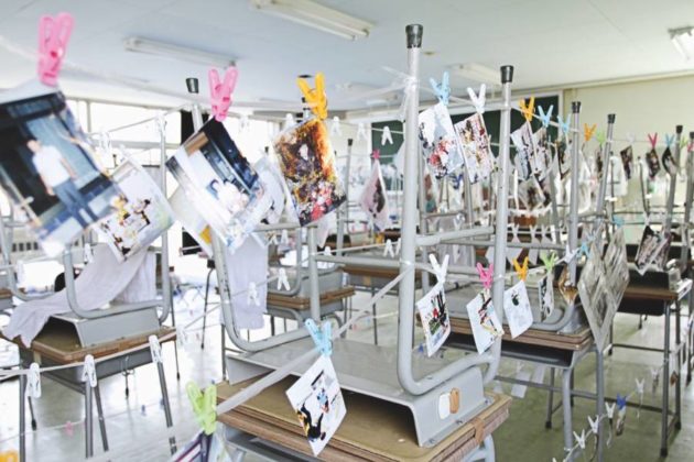 In the photo, the rescued photographs are placed to dry on an improvised clothesline using the chairs themselves to lift the wire where the photos are fastened with colored fasteners.