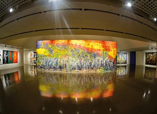 Pintura horizontal "Rio Amazonas", de Aguilar, em meio à uma sala de exposição.