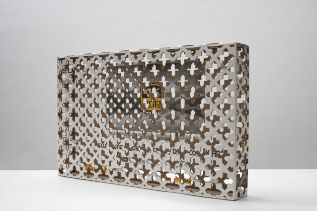 Horizontal, color image. CONFÉSION, by Jorge Macchi, cardboard box for 50-inch smart TVs whose surface features a cross-cut pattern that refers to the perforated metal of confessionals