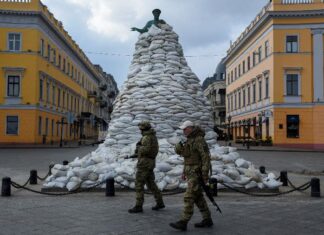 Soldados caminham por monumento coberto por sacos de areia em Odessa, na Ucrânia, em meio à invasão da Rússia. Foto: Alexandros Avramidis/Reuters