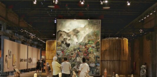 A Modernidade em questão Vista de "A parábola do progresso", em egundo plano, obra "Invasão do Alemão", de Márcia Falcão